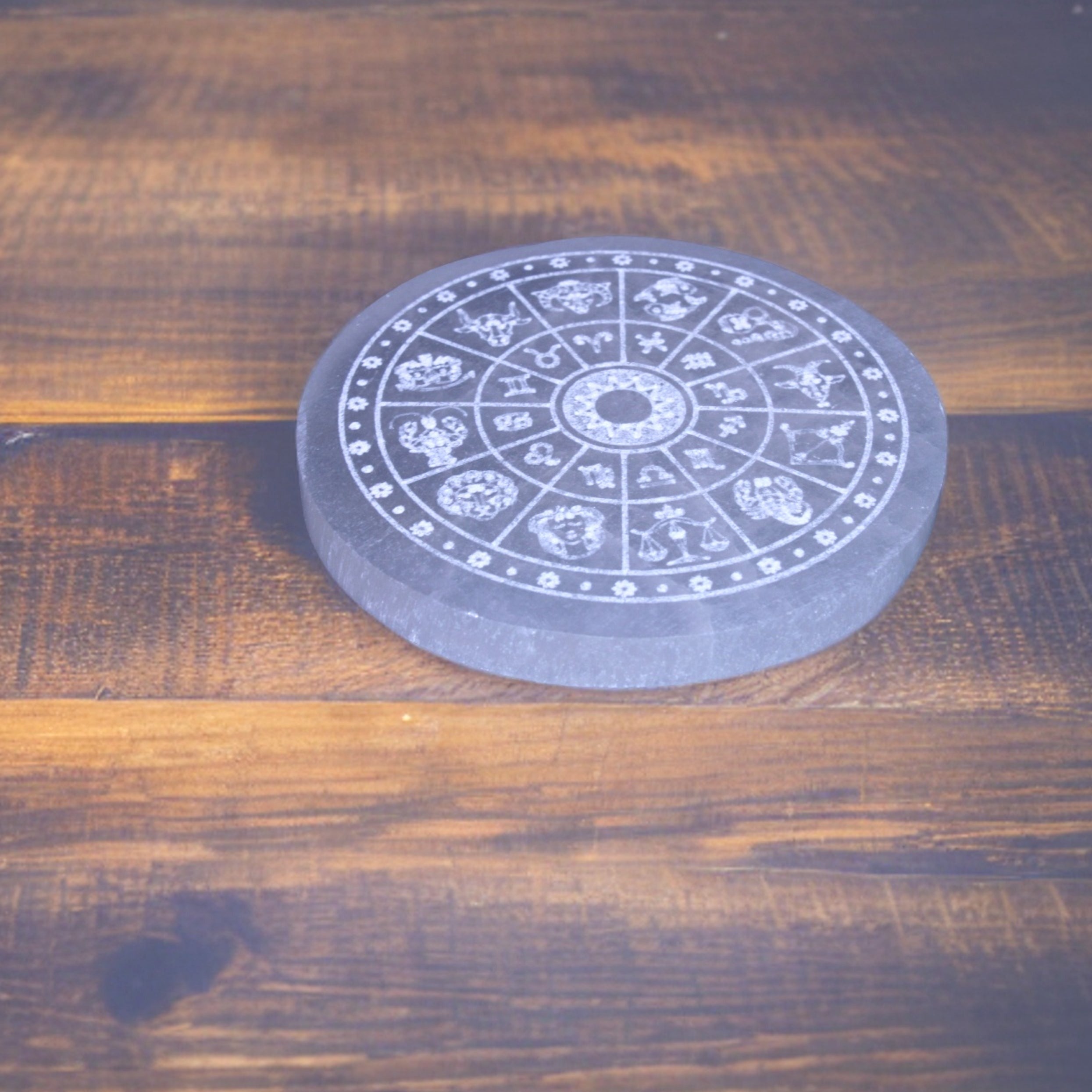 selenite zodiac plate in wooden floor